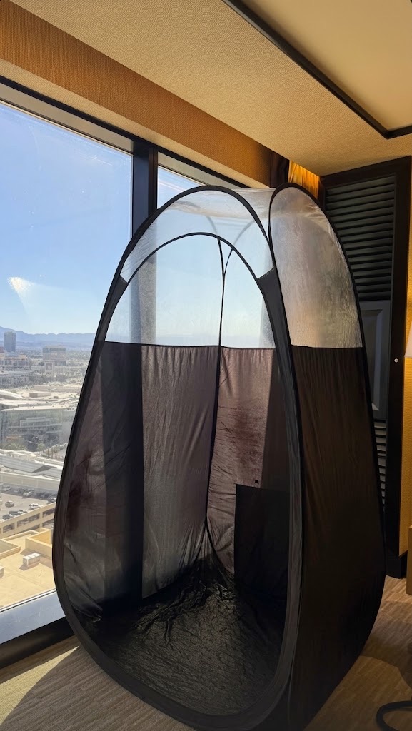 A pop-up tanning tent set up in a Las Vegas hotel suite, the Strip beyond the window